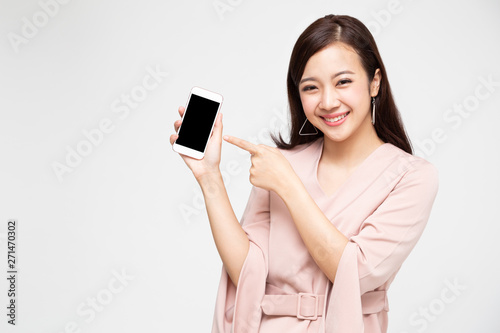 Portrait of beautiful Asian wowan showing or presenting mobile phone application on hand isolated over white background photo