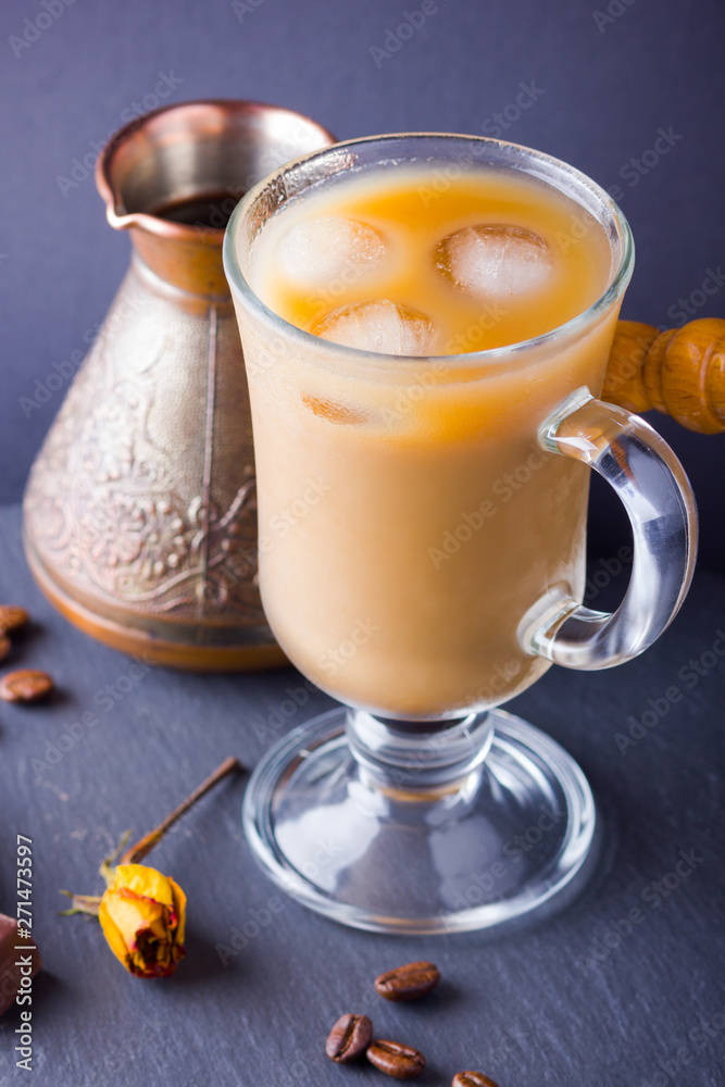 Copper coffee pot (Cezve) and coffee beans. Coffee with milk on dark background. Latte and black chocolate on slate board. Milk drink in glass beaker and dried rose Copper coffee pot (Cezve) and coffee beans. Coffee with milk on dark background. Latte and black chocolate on slate board. Milk drink in glass beaker and dried rose