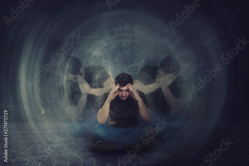 Canvas Print Man seated on the floor, hands to head, suffer split emotions into different inner personalities