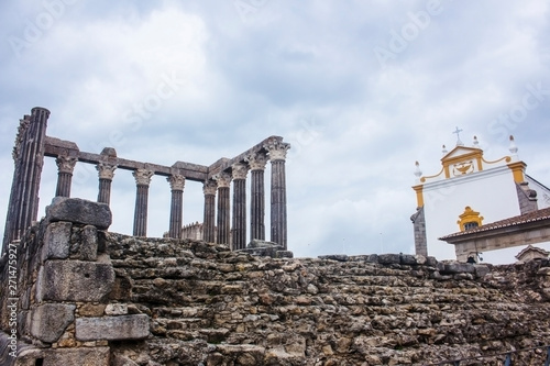 Ruins of the Roman Temple of Evora dedicated to Diana, and the Sao Joao Evangelista Church. In Evora, Portugal. photo