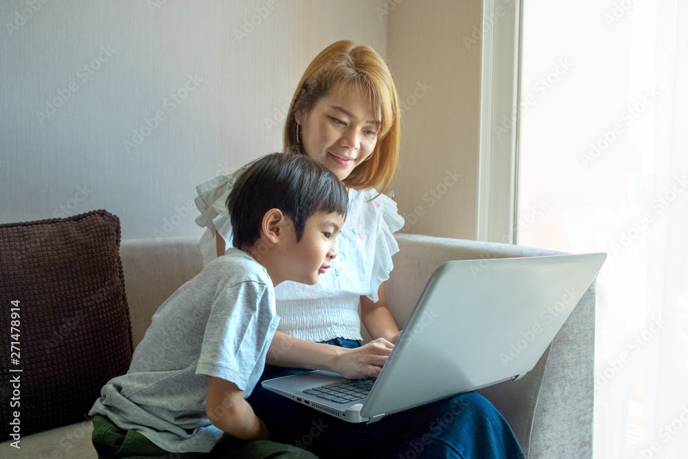 Asian Mother teaching her son for use laptop computer Asian Mother teaching her son for use laptop computer