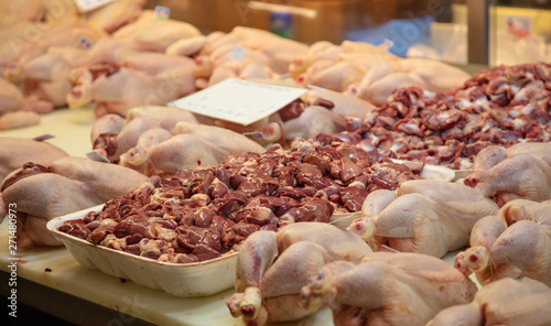 Fresh chickens and their livers in row out of butcher shop. Uncooked giblets background, poultry, closeup.