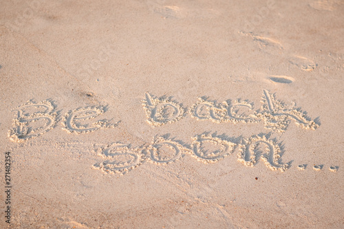 The Words "Be Back Soon" Written in the Sand