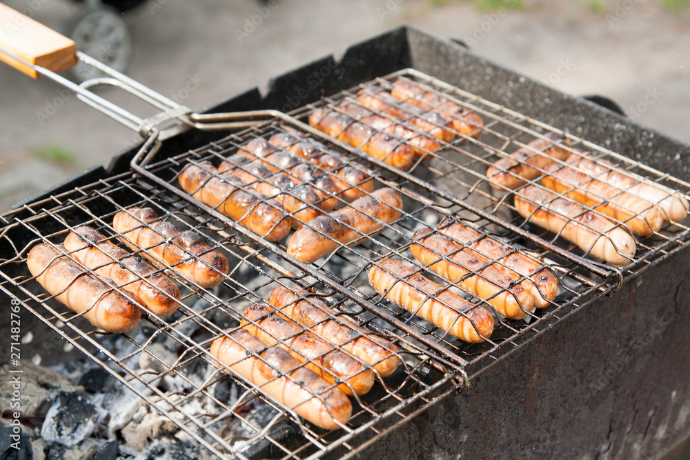 sausages in a grid roast on coals - camping concept photo