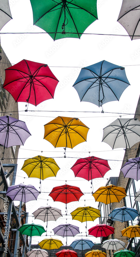 colorful street art umbrellas in dublin hanging in pattern above street in temple bar destrict - symbol for joy and fun