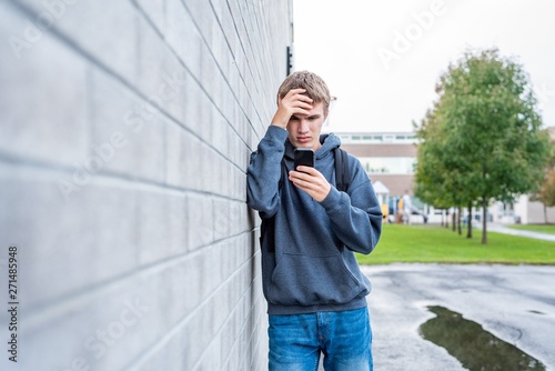 Teenager viewing something upsetting on his cellphone.