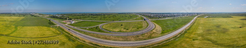 Aerial panoramic view of transportation highway overpass, ringway, roundabout, urban traffic