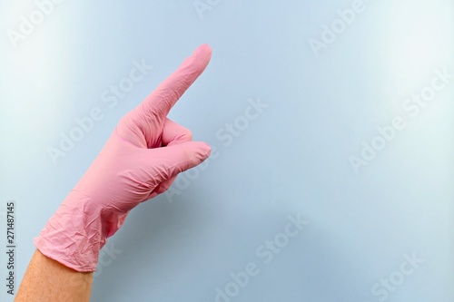 The index finger of a gloved hand points out.