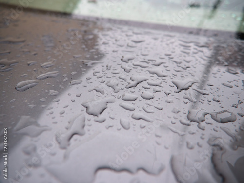 Close up of water droplets on grey car.