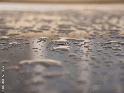 Close up of water droplets on grey car.