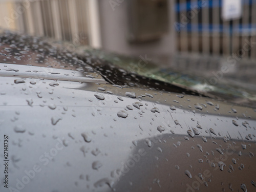 Close up of water droplets on grey car.