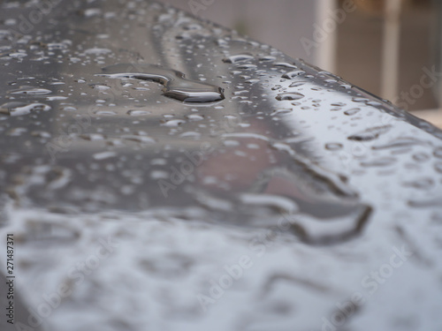 Close up of water droplets on grey car.