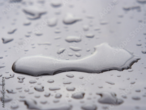 Close up of water droplets on grey car.