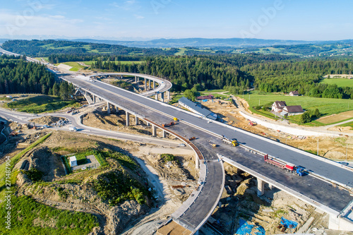 New highway under construction in Poland on national road no 7, E77, called Zakopianka. Overpass crossroad with traffic circles and viaducts near Naprawa village. Aerial view in June 2019