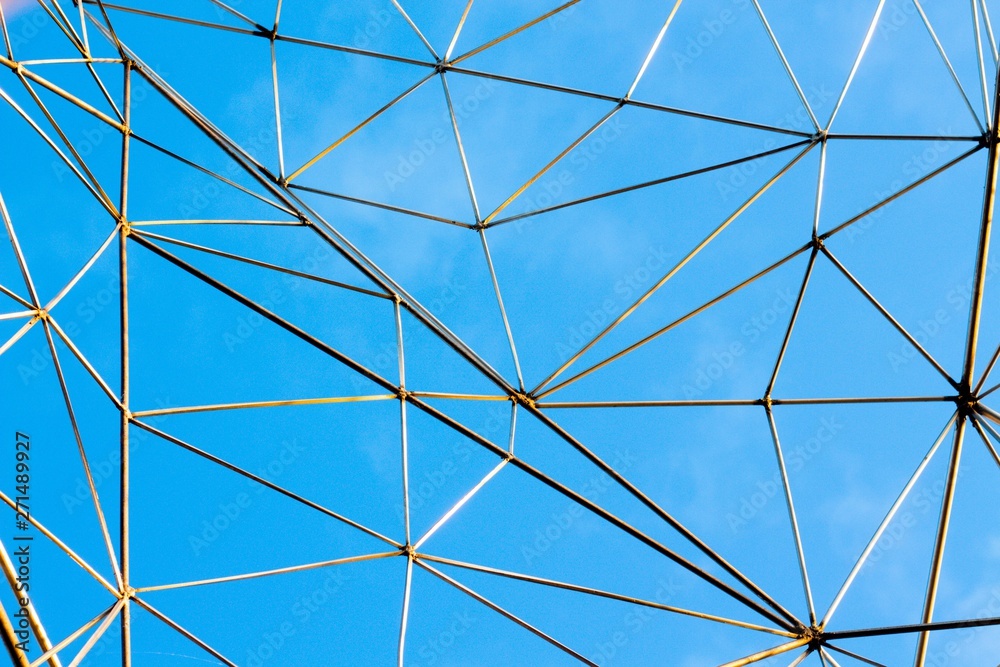 Obraz premium Large metal mesh on a background of clean blue sky. The net is made to catch the clouds.