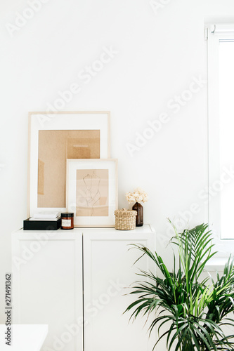 Modern minimal Scandinavian nordic interior design. Chest of drawers  photo frames  palm home plant and decor.