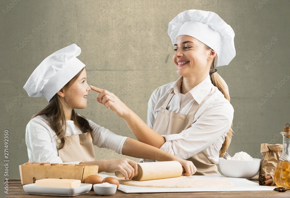 Portrait of adorable little girl and her mother baking together Portrait of adorable little girl and her mother baking together
