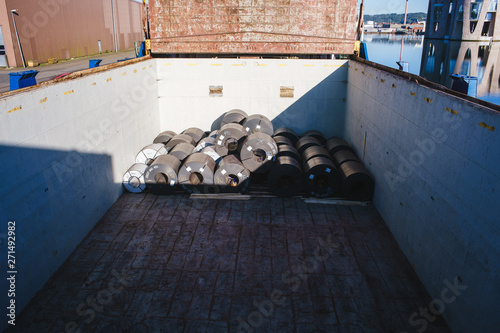 Cargo hold of general cargo ship. Coils in cargo holds. View from hatch cover. Ship moored in the port. photo