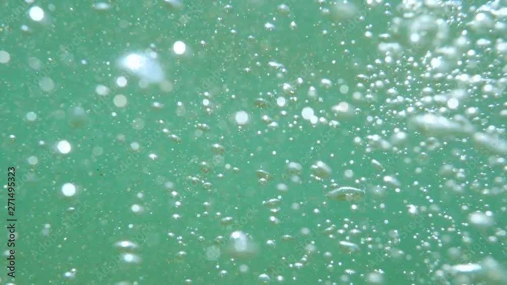 Bubbles rising to the surface. Slow motion. Air bubbles in clear blue water (underwater shot), good for backgrounds