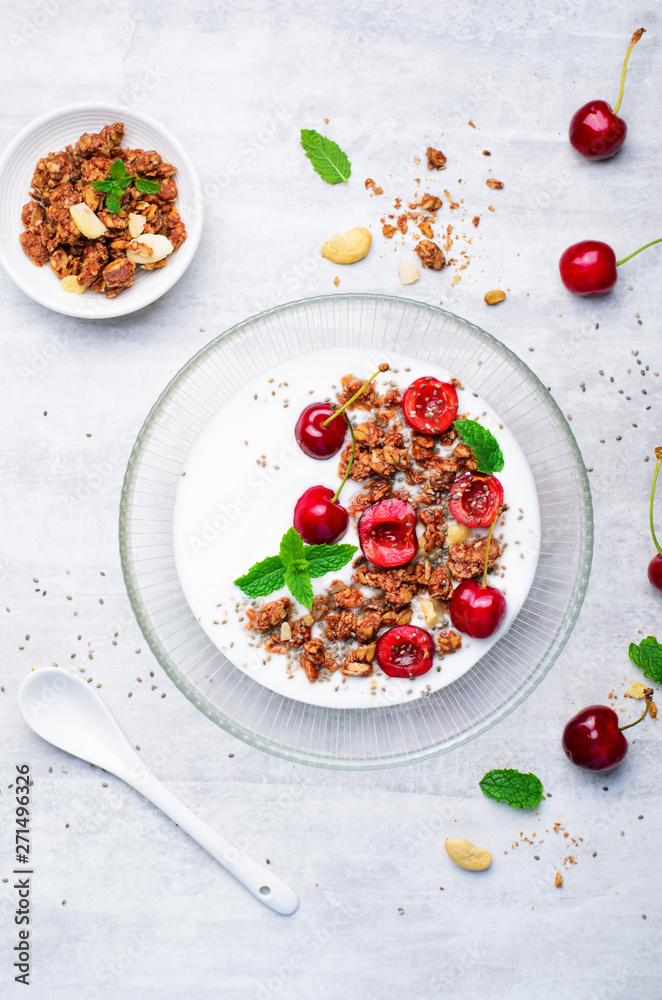 Yogurt with Cherries, Granola and Chia Seeds over Bright Background Yogurt with Cherries, Granola and Chia Seeds over Bright Background