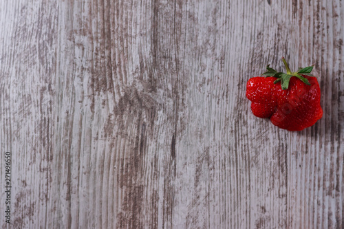 Ugly strawberries on a light background
