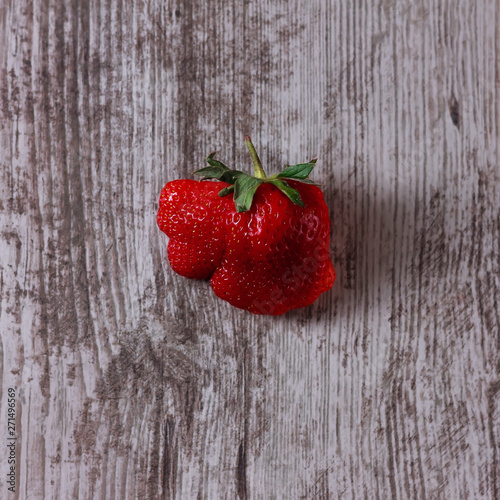 Abnormal strawberries shape put on the wood background