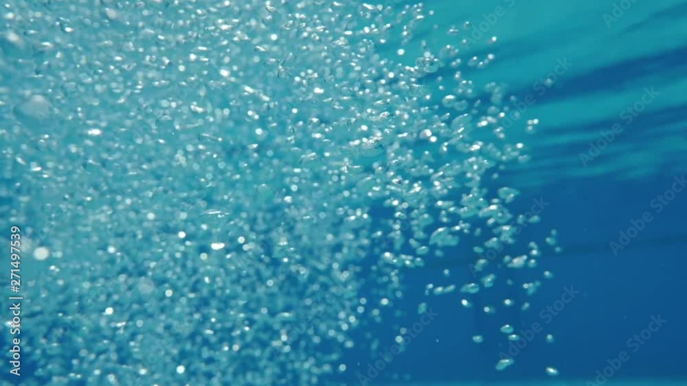 Bubbles rising to the surface. Slow motion. Air bubbles in clear blue water (underwater shot), good for backgrounds