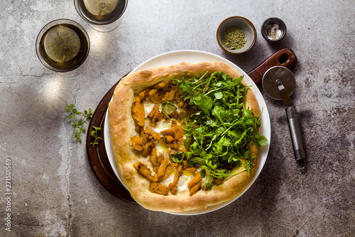 traditional Italian white pizza with taleggio cheese, caramelized pumpkin and arugula on the table
