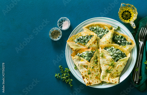 Принти на полотні Traditional Italian pancakes crepes with spinach and ricotta on a served blue table