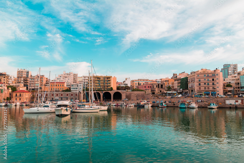 hue shifted photo of heraklion city old port panoramic view sea sky boats floating and building vintage look