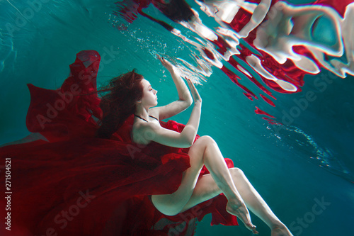 Bilde på lerret Mystical underwater portrait of a beautiful young woman in a red dress