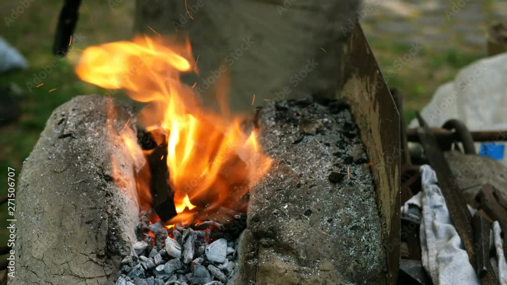Blacksmith is engaged in the manufacture of metal products in mobile mini forge outdoors. Blacksmith is engaged in the manufacture of metal products in mobile mini forge outdoors.