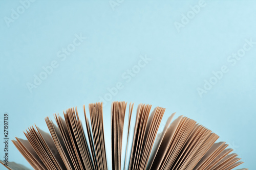 Book stacking. Open book  hardback books on wooden table and blue background. Back to school. Copy space for text.