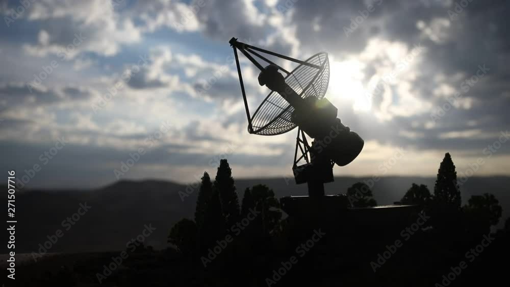 Silhouettes of satellite dishes or radio antennas against night sky. Space observatory or Air defence radar over dramatic sunset sky. Creative artwork decoration. Selective focus Silhouettes of satellite dishes or radio antennas against night sky. Space observatory or Air defence radar over dramatic sunset sky. Creative artwork decoration. Selective focus