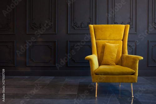 Stylish bright yellow chair against a dark gray wall photo