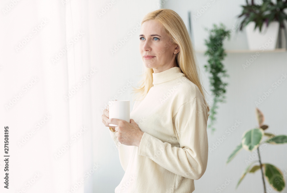 Middle-Aged Woman Drinking Coffee And Looking Through Window Middle-Aged Woman Drinking Coffee And Looking Through Window