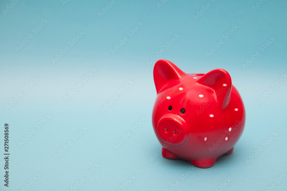 classic red piggy bank in white polka dot on a blue background.