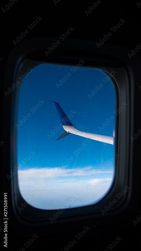 Plane Wing through the Window Above The Sky