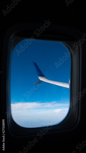 Plane Wing through the Window Above The Sky