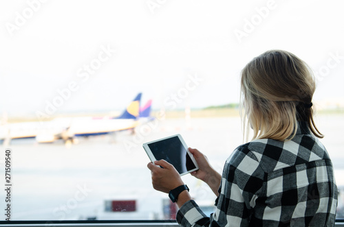 MAY 5 2016 - BUDAPEST, HUNGARY: woman looking at tablet and ryanair airplane at airport