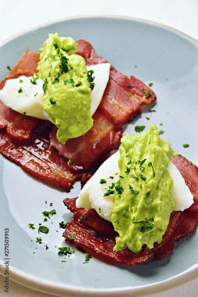 Paleo eggs benedict with avocado sauce on a bacon mat Paleo eggs benedict with avocado sauce on a bacon mat