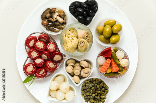 Italian traditional pickles on a plate. tuna stuffed peppers, artichokes in oil, olives, mushrooms, capers. copy space.