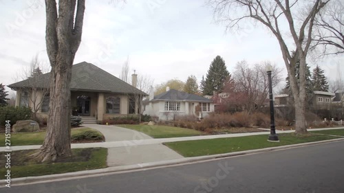 View down a street of an established neighbourhood with houses and large trees; Edmonton, Alberta, Canada