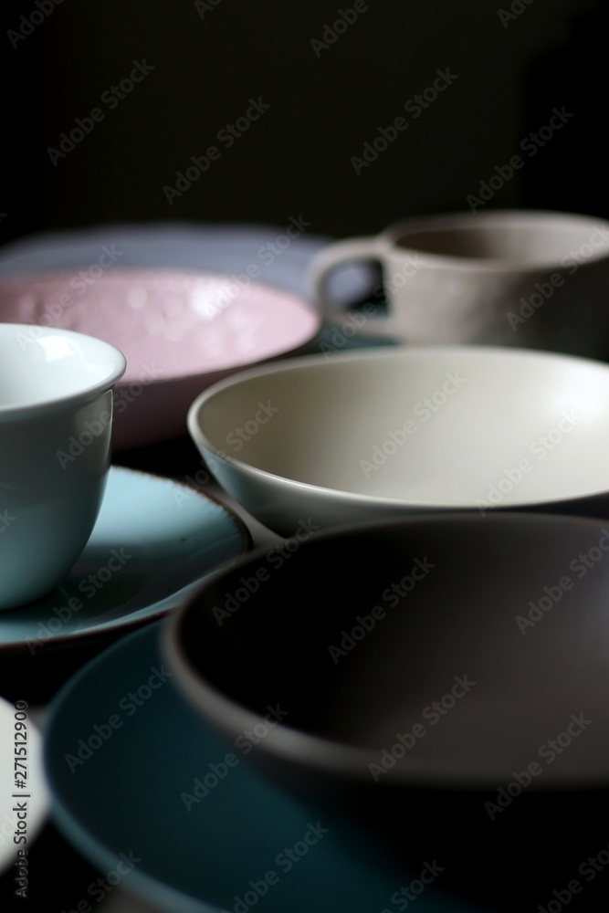 Collection of pottery and kitchenware in muted pastel colors. Selective focus.