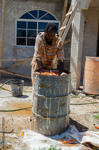 Man Washing Carrots In Drum © Jacquelin