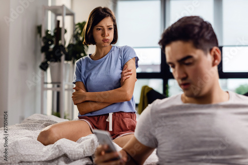 Stressed out woman with arms crossed frowning at her boyfriend.
