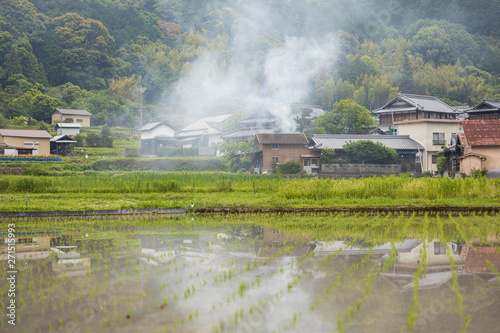 Smoke rises over small Japanese village as a result of farmer burning refuse