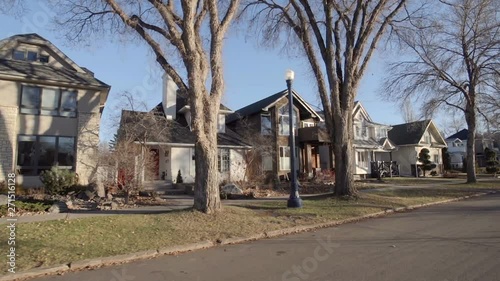 View down a street of an established neighbourhood with houses and large trees; Edmonton, Alberta, Canada