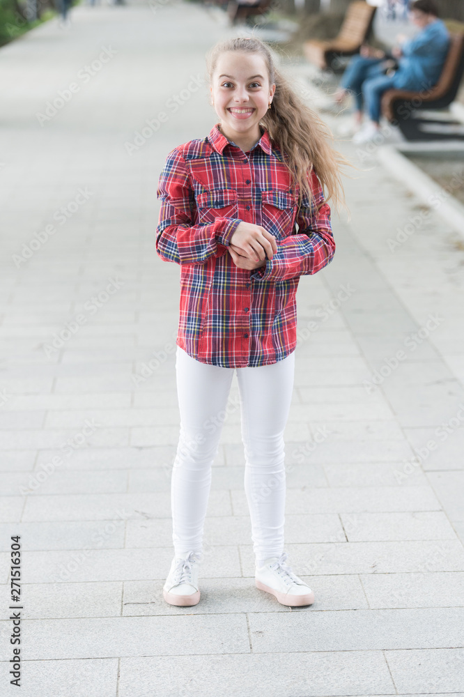 Casual silhouette with a relaxed fit. Happy small girl wearing casual and plaid shirt. Casual look of smiling little child. Adorable kid dressed for a casual day outdoor