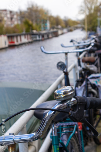 AMSTERDAM, NETHERLANDS - APRIL 13, 2019: Bicycles lining a bridge over the canals of Amsterdam